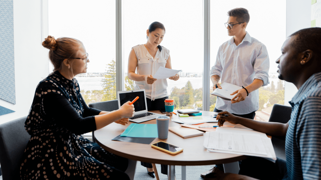 Manager and employees discussing progress during a performance check-in.